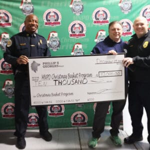 Attorney Phil Georges and two MNPD officers hold a giant check for a $10,000 donation to the Christmas Basket Program.